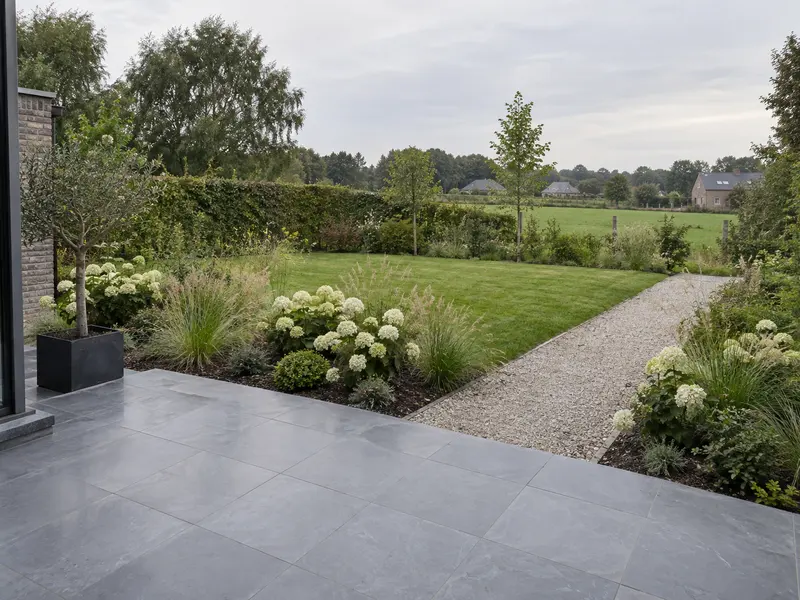 Terrasse en pierre bleue et massifs plantés, jardin de particulier